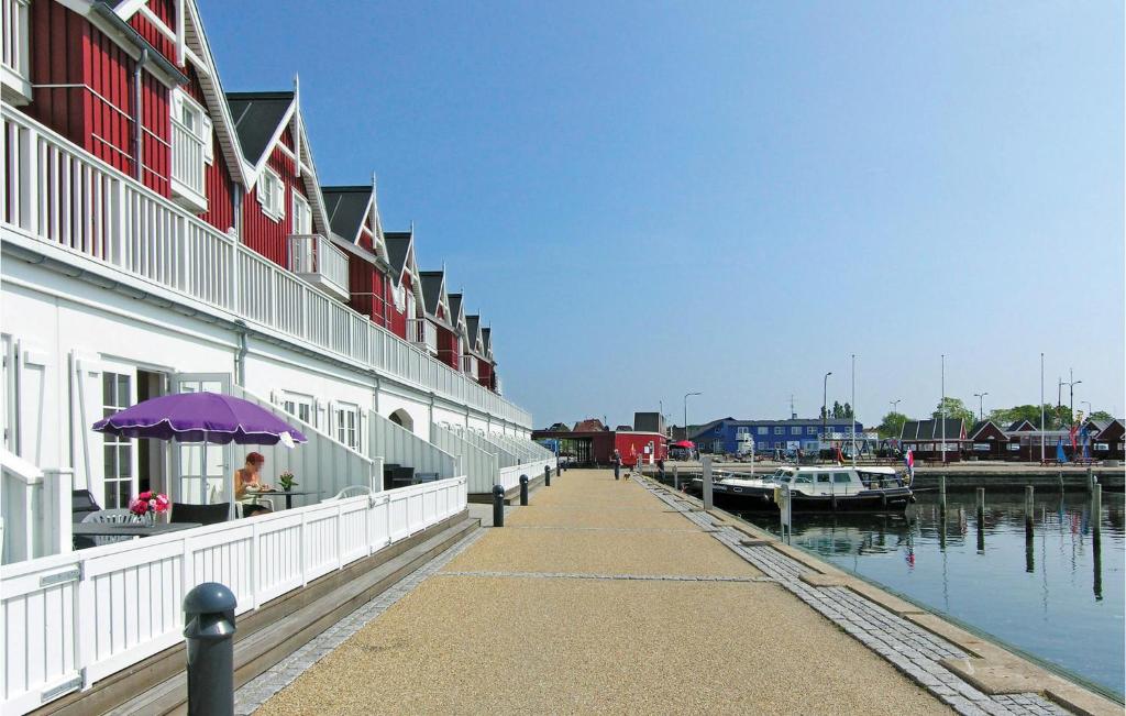 a building with a purple umbrella next to a marina at 2 Bedroom Awesome Apartment In Bagenkop in Bagenkop