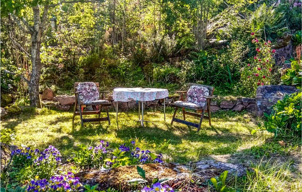 2 Stühle und ein Tisch in einem Garten mit Blumen in der Unterkunft Nice Home In Sande I Vestfold With House A Panoramic View in Svelvik