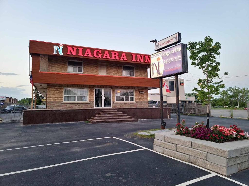 a nicacca inn with a sign in a parking lot at Niagara Inn in Niagara Falls