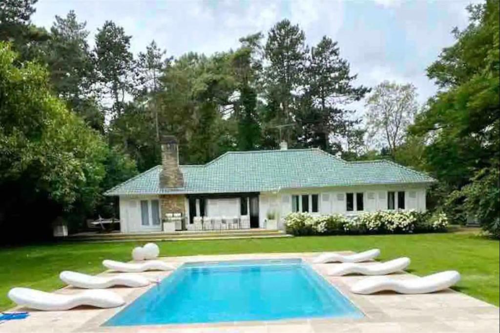 a house with a swimming pool in front of a house at Magnifique villa golf du Touquet in Le Touquet-Paris-Plage