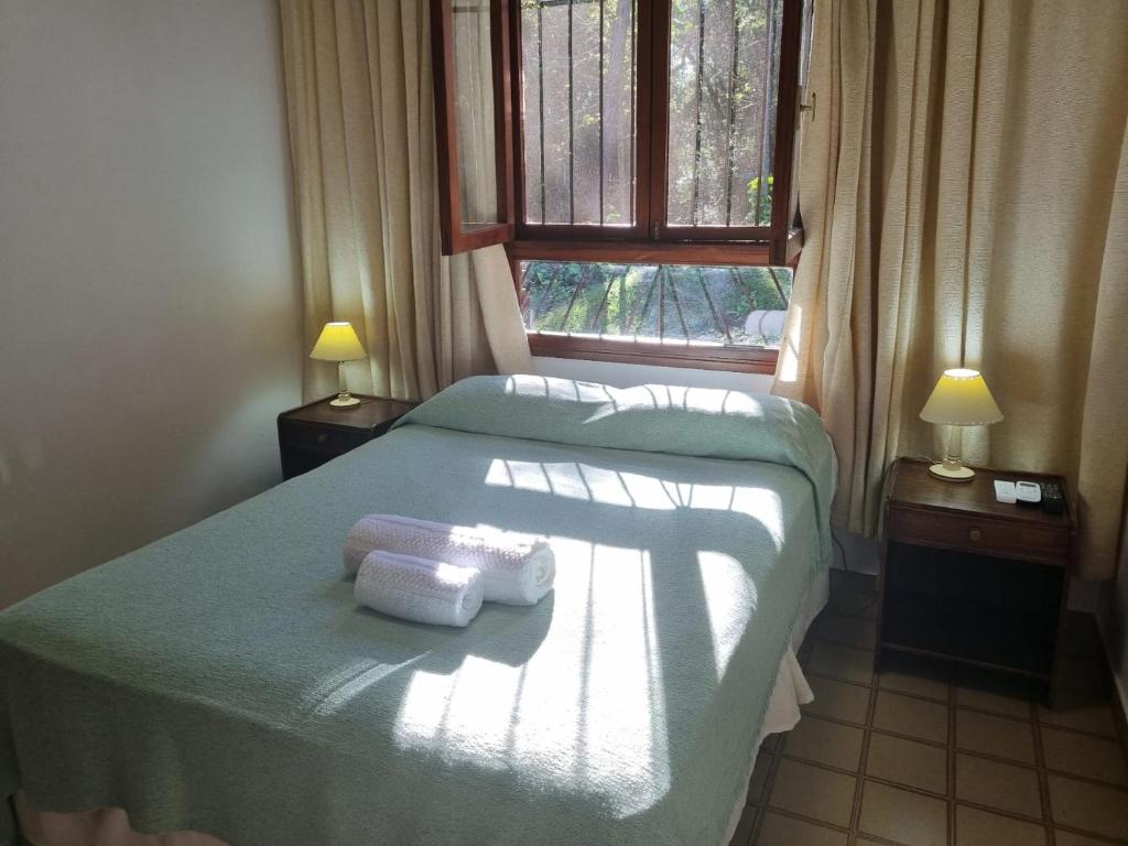 a bedroom with two beds and a window with towels at Hotel ACA Eldorado in Eldorado