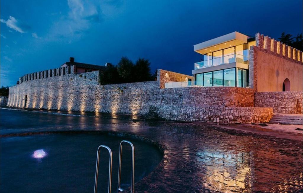 a building next to a brick wall next to the water at Villa Lorena in Novigrad Istria