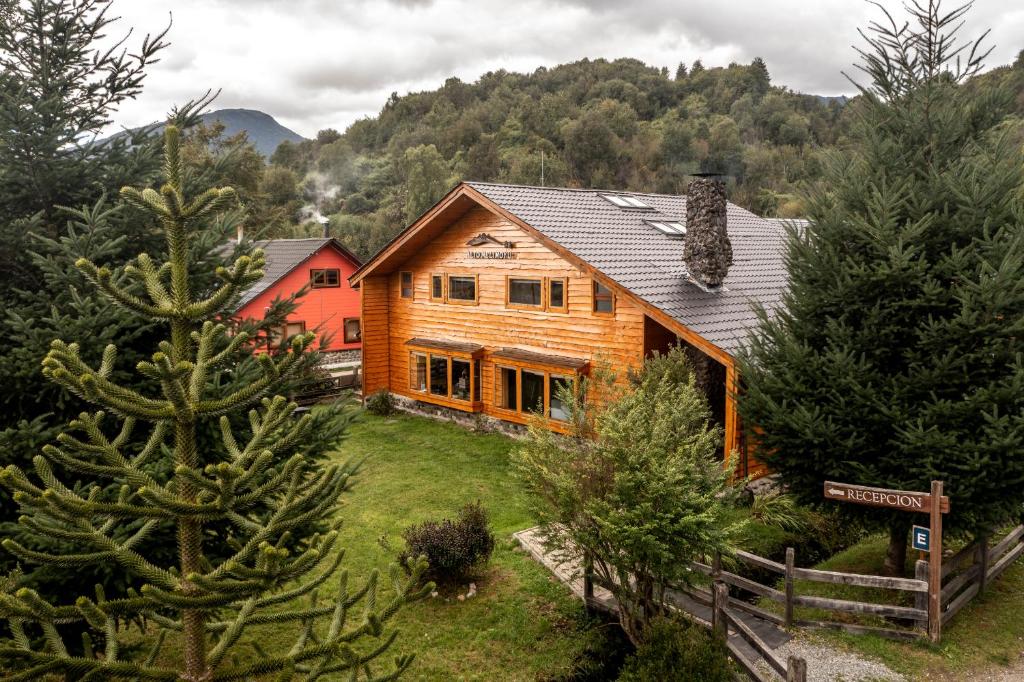a log cabin in the mountains with trees at Alto Melimoyu Hotel & Patagonia in La Junta