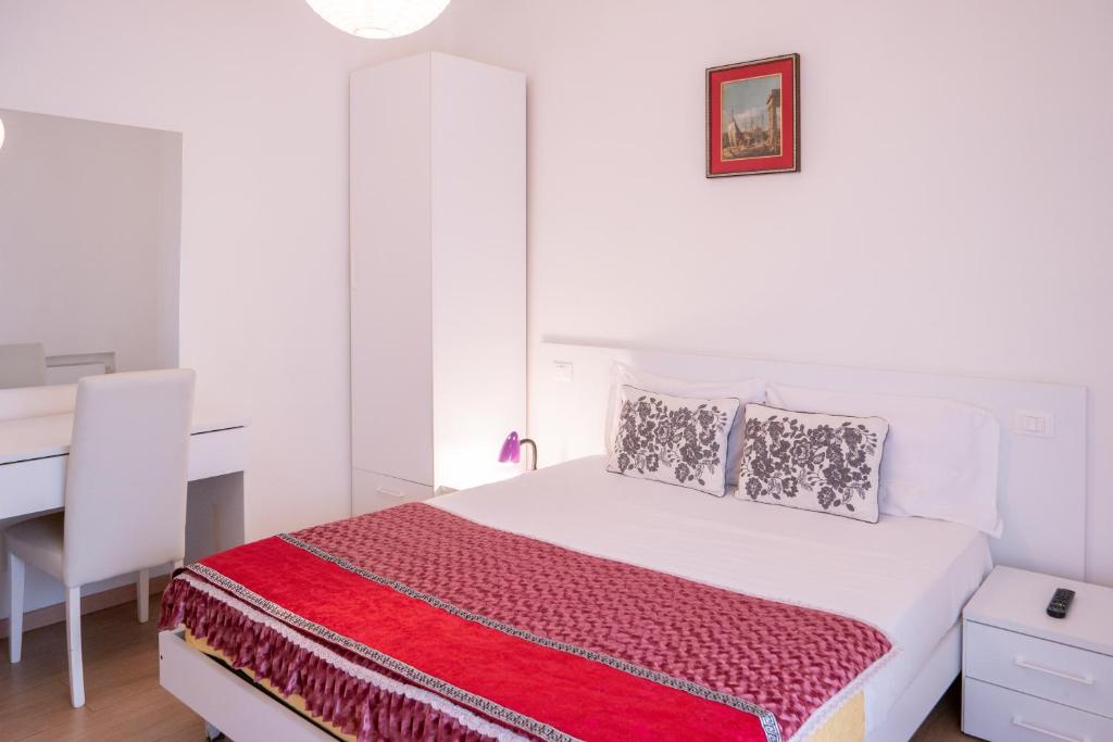a white bedroom with a bed and a desk at Ca' Popolo Venice in Mestre
