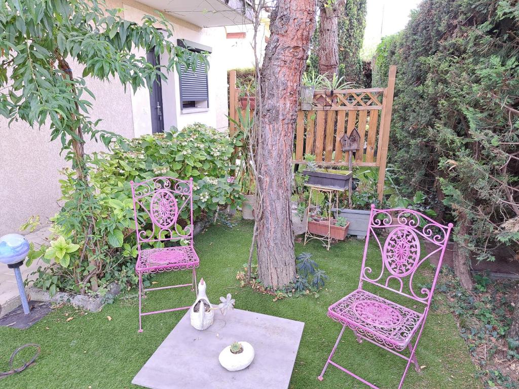 two chairs and a table in a yard with a tree at Studio Cécilia in Aix-les-Bains