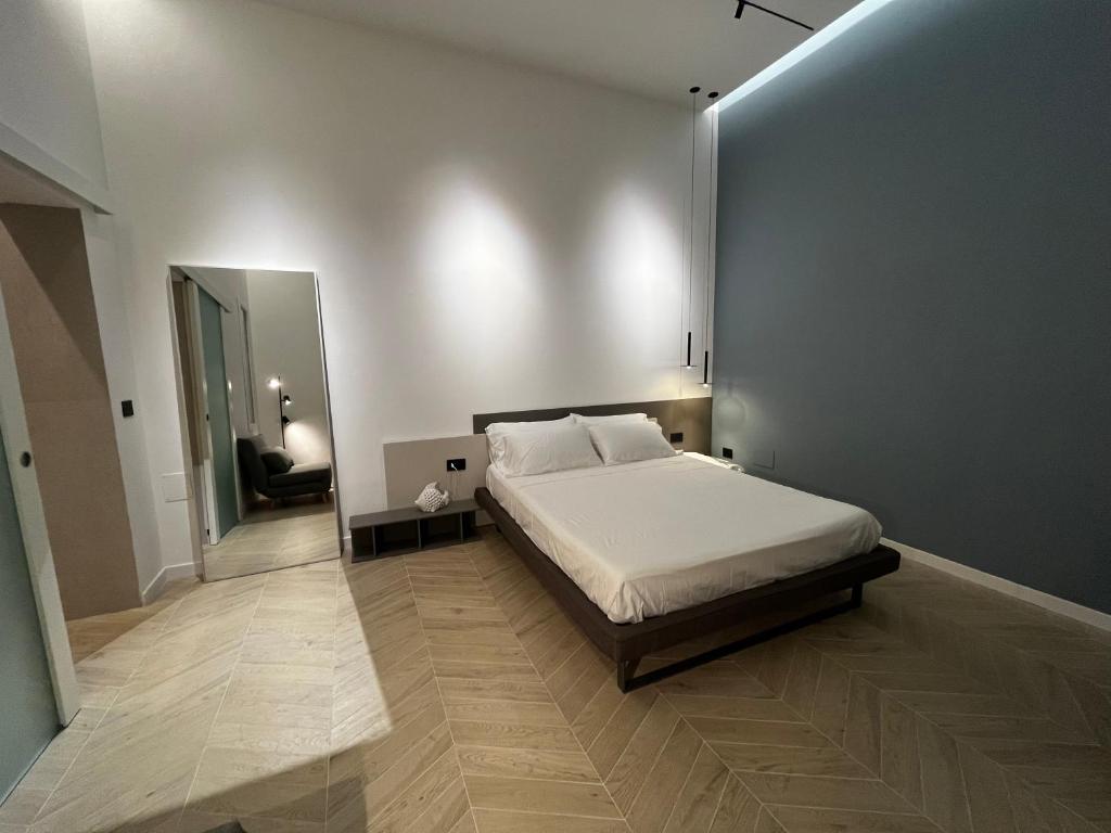 1 dormitorio con 1 cama grande y espejo en Central Suite 81 en Pescara