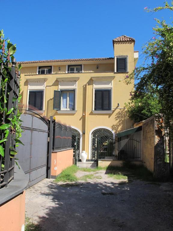 una casa amarilla con una puerta y una valla en Paluardi Maison de Charme, en Nocera Superiore