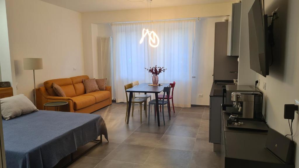 Habitación con cama, mesa y sofá en Appartamentino In Piazza, en Grottammare
