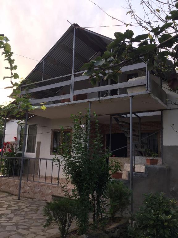 a house with a balcony in front of it at Mera Hostel in P'arts'khanaqanevi