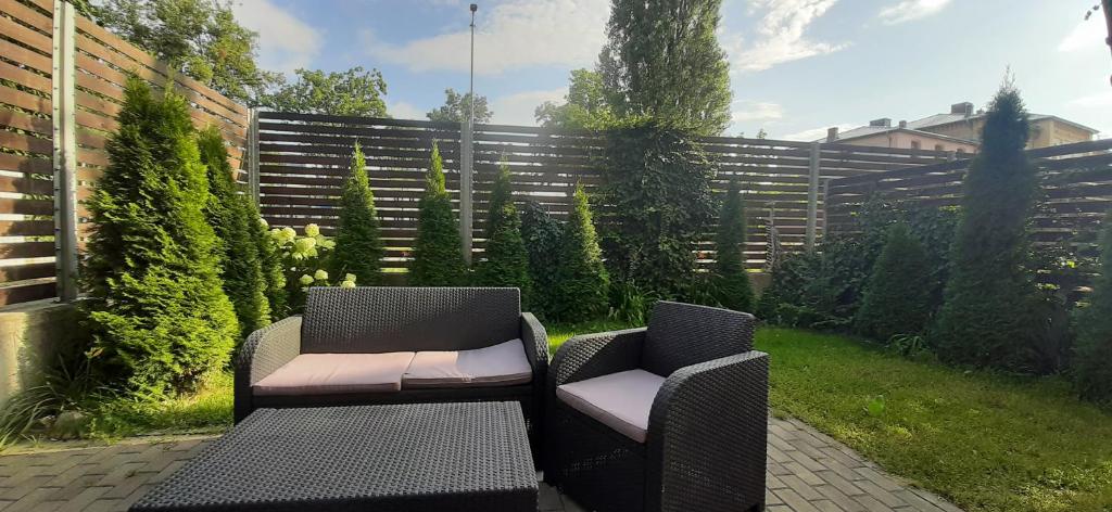 2 chaises et une table dans un jardin dans l'établissement Przystań, à Ostróda