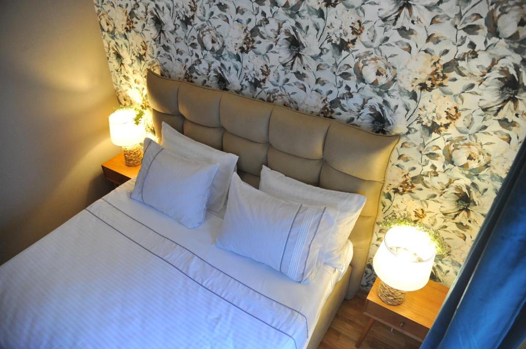 a bedroom with a bed with white sheets and pillows at Apartman Ljubica in Vrnjačka Banja