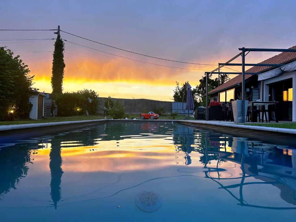 an empty swimming pool with a sunset in the background at la petite bulle in Montagnat