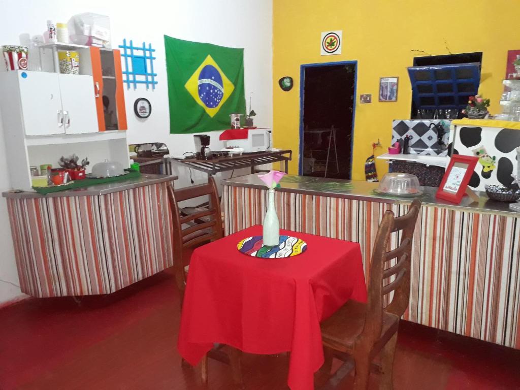 a kitchen with a table with a red table cloth at Perto Do Aeroporto De Salvador - Dona Pitanga Hostel in Lauro de Freitas