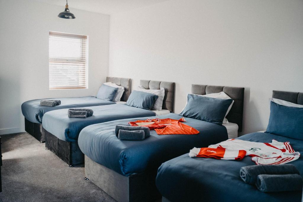 a room with three beds with clothes on them at Flat Iron Anfield in Liverpool