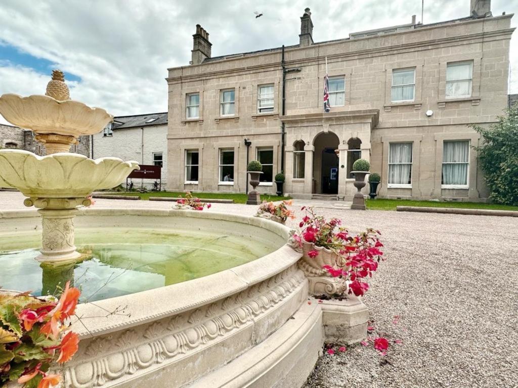a fountain in front of a large building at Montigo Resorts, Somerset in Shepton Mallet
