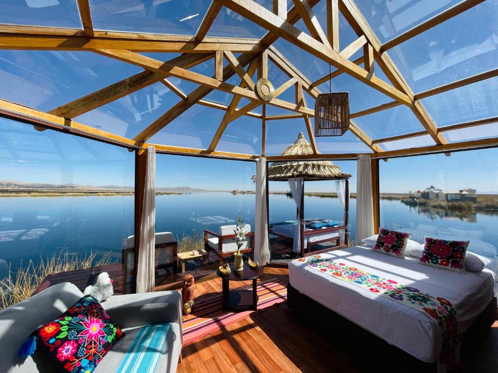 a room with a bed and a view of the water at Titicaca Ecolodge Perú in Puno