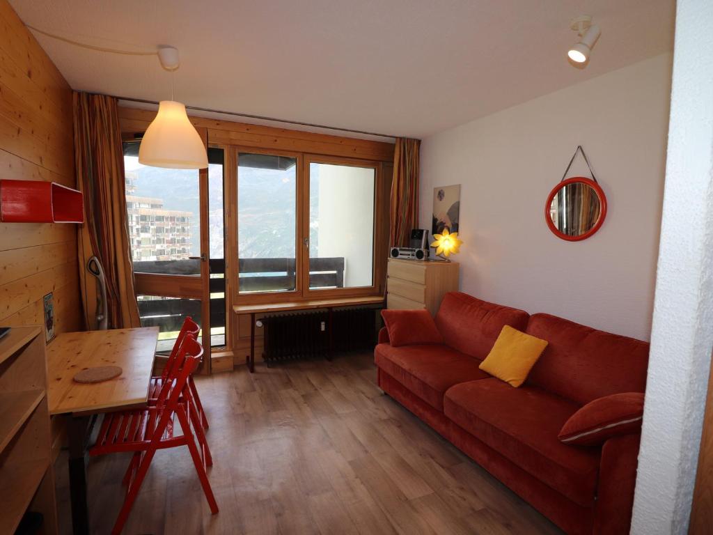 un salon avec un canapé rouge et une table dans l'établissement Studio rénové proche pistes avec balcon - FR-1-502-386, à Tignes
