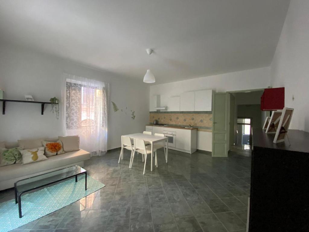 ein Wohnzimmer mit einem Sofa und einem Tisch in der Unterkunft Dimora Zefiro vacanze in Gioiosa Marea