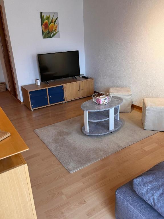 a living room with a tv and a coffee table at Gaby in Grächen