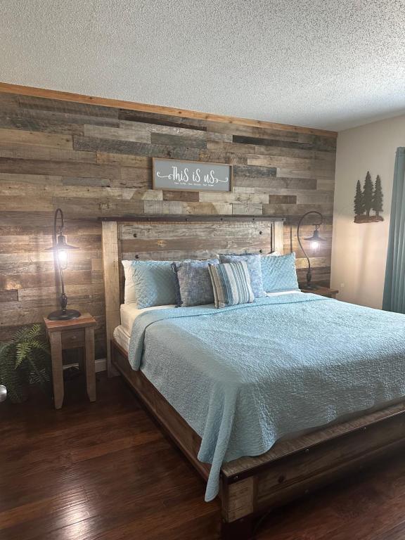 ein Schlafzimmer mit einem Bett mit einer Holzwand in der Unterkunft River Place Condos #206 2BD in Pigeon Forge
