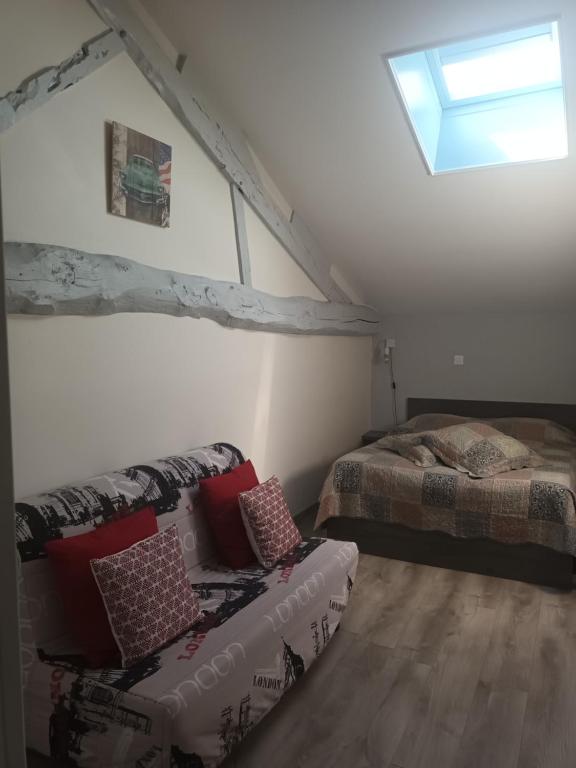 1 dormitorio con cama, sofá y ventana en Appartement a la campagne en Grièges
