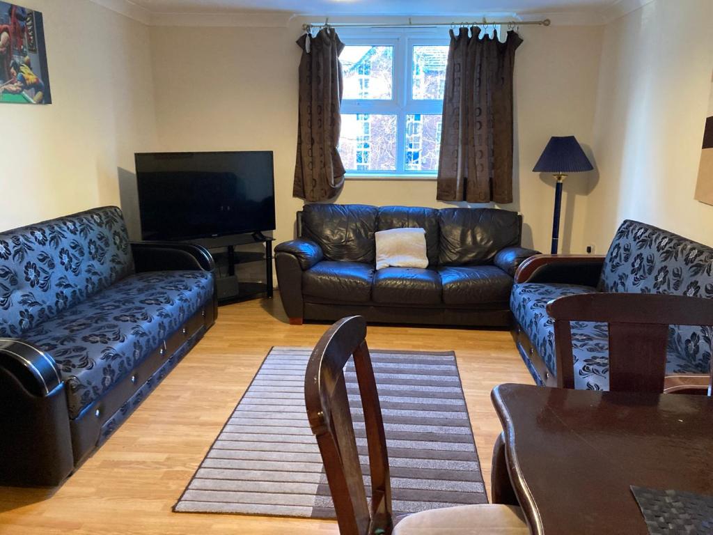 a living room with two couches and a tv at Cosy Apartment in Manchester