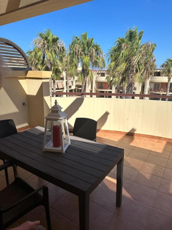 a table and chairs on a patio with palm trees at Le terrazze di Rosa in Polignano a Mare