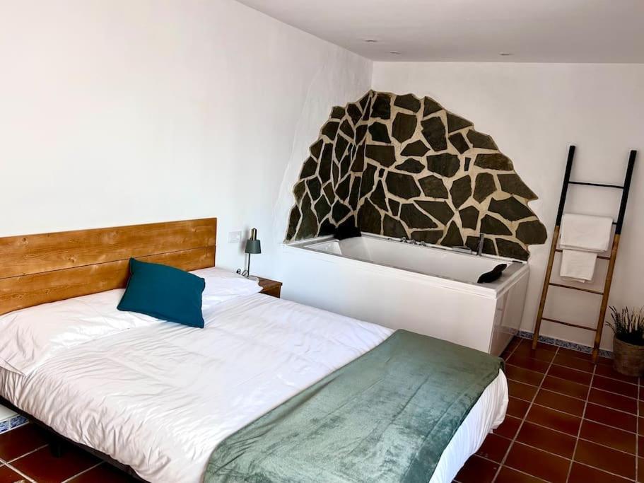 a bedroom with a large bed and a large wall at Jacuzzi en Benaocaz by CadizTime Apartments in Benaocaz