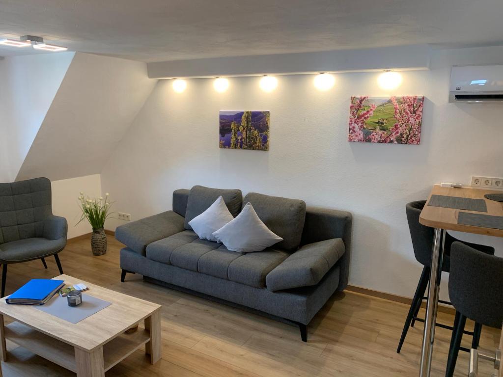 uma sala de estar com um sofá e duas pinturas na parede em Ferienwohnung Michael em Bremm