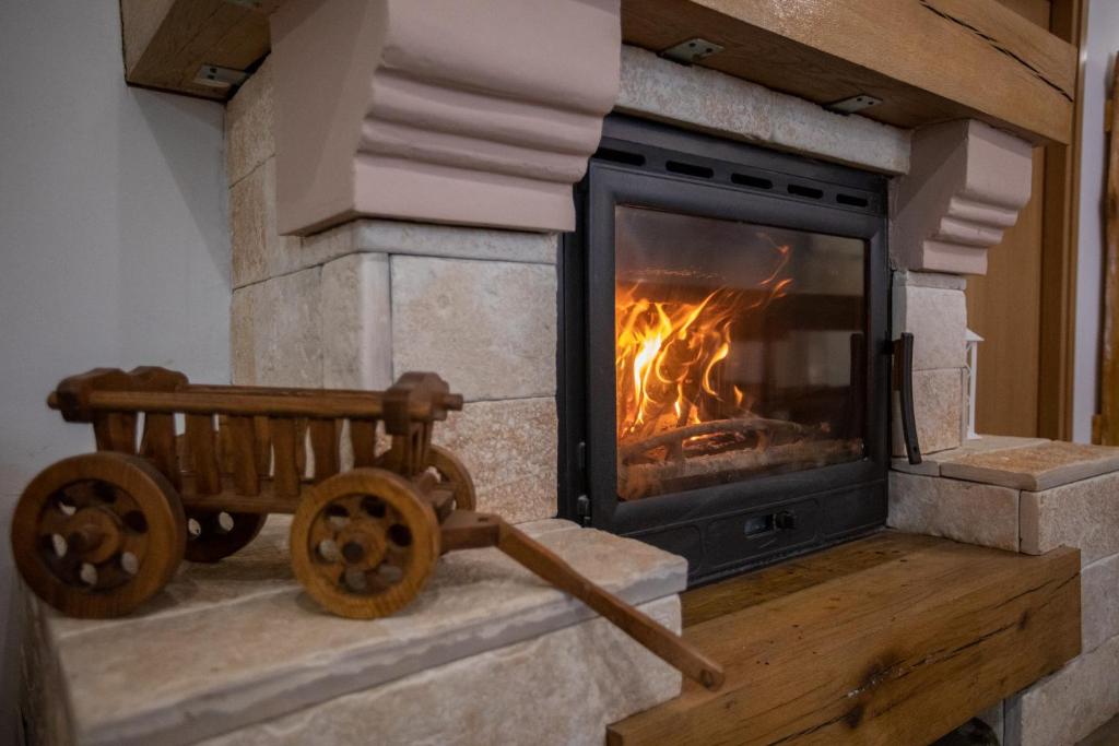 een stenen open haard met een vuur erin bij Apartmani Lara Modruš-Kuća za odmor in Modruš