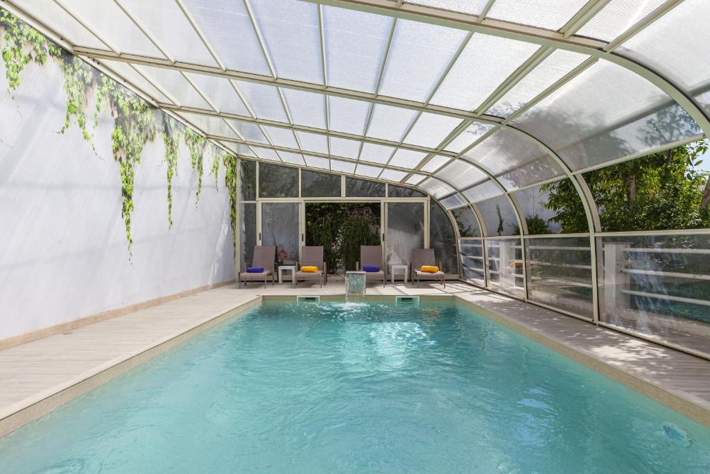 a swimming pool with a glass ceiling and an indoor swimming poolvisor at Boutique Hotel Casa do Outeiro - Arts & Crafts in Batalha