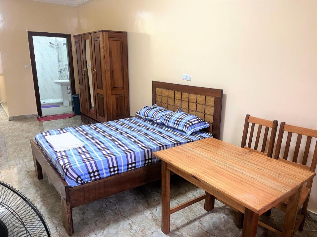 1 dormitorio con cama y mesa de madera en CHAMBRES PRIVEE-APPARTEMENT VUE SUR MER en Dakar