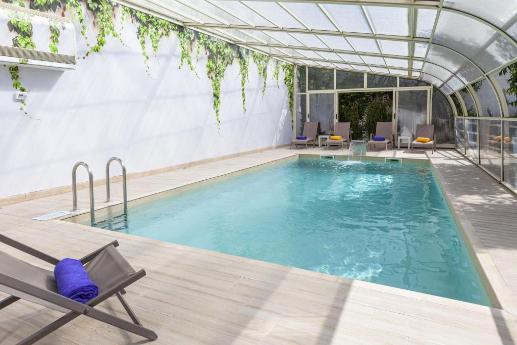 a large swimming pool with a chair and a table at Boutique Hotel Casa do Outeiro - Arts & Crafts in Batalha