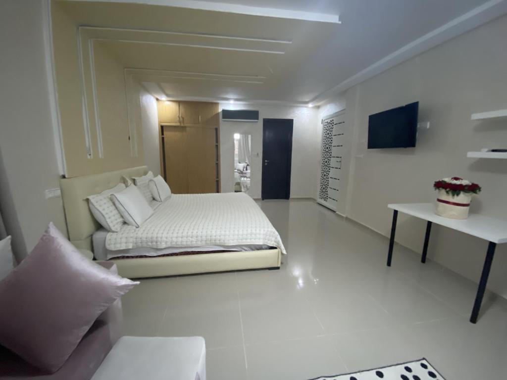 um quarto branco com uma cama e uma mesa em Chambres luxueuses em Ouazzane
