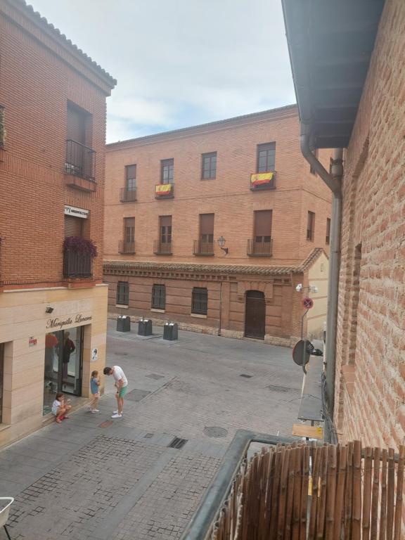 dos niños jugando en el patio de un edificio en Apartamentos RyC, en Alcalá de Henares