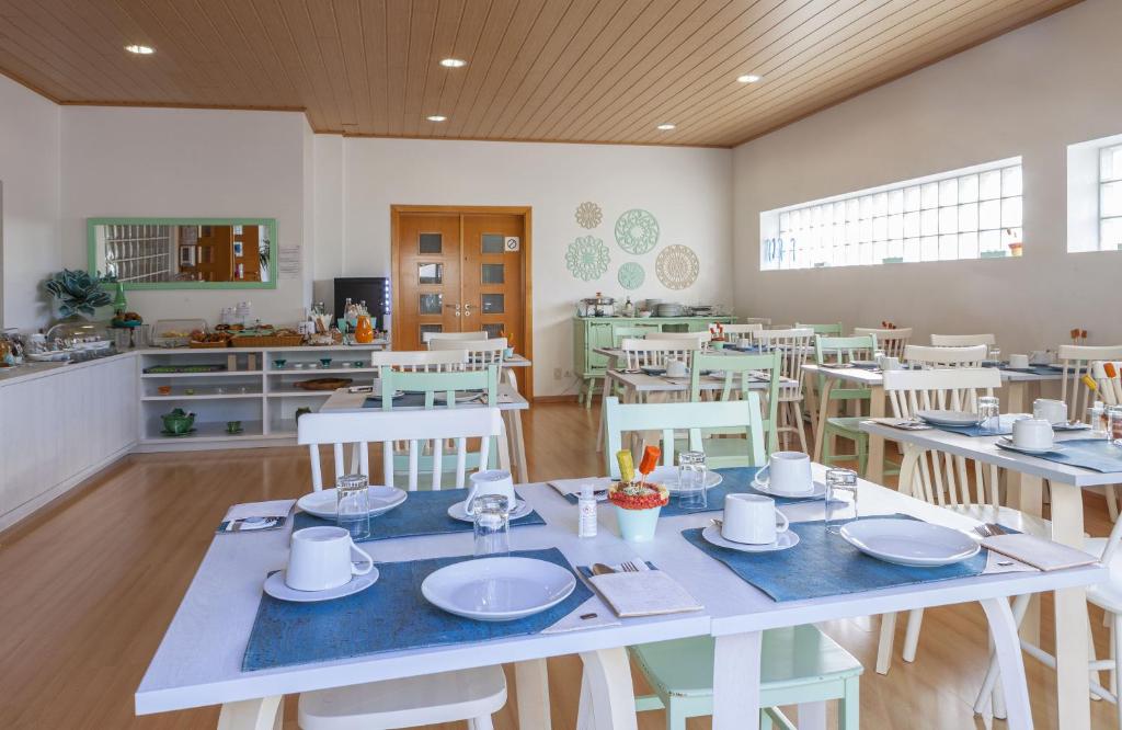 a dining room with white tables and white chairs at Boutique Hotel Casa do Outeiro - Arts & Crafts in Batalha