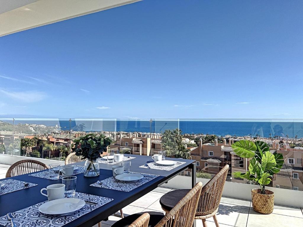 a table on a balcony with a view of the city at Via Celere 2329 Luxury apartment with Sea View in Casares