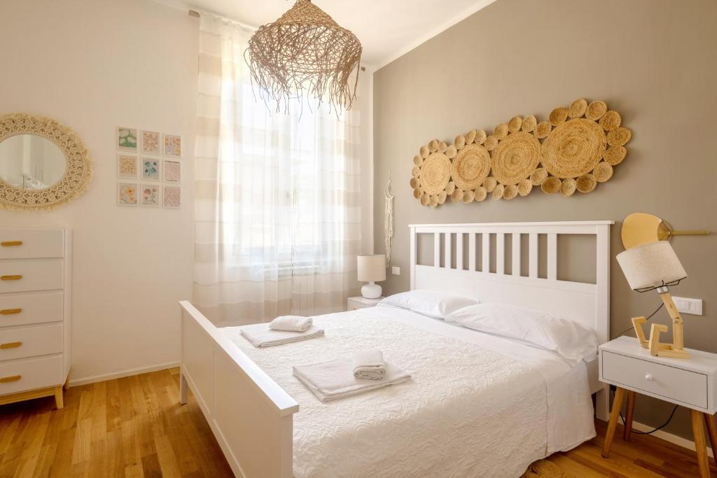 Dormitorio blanco con cama blanca y espejo en A CA' DU BARBA ALE, en La Spezia