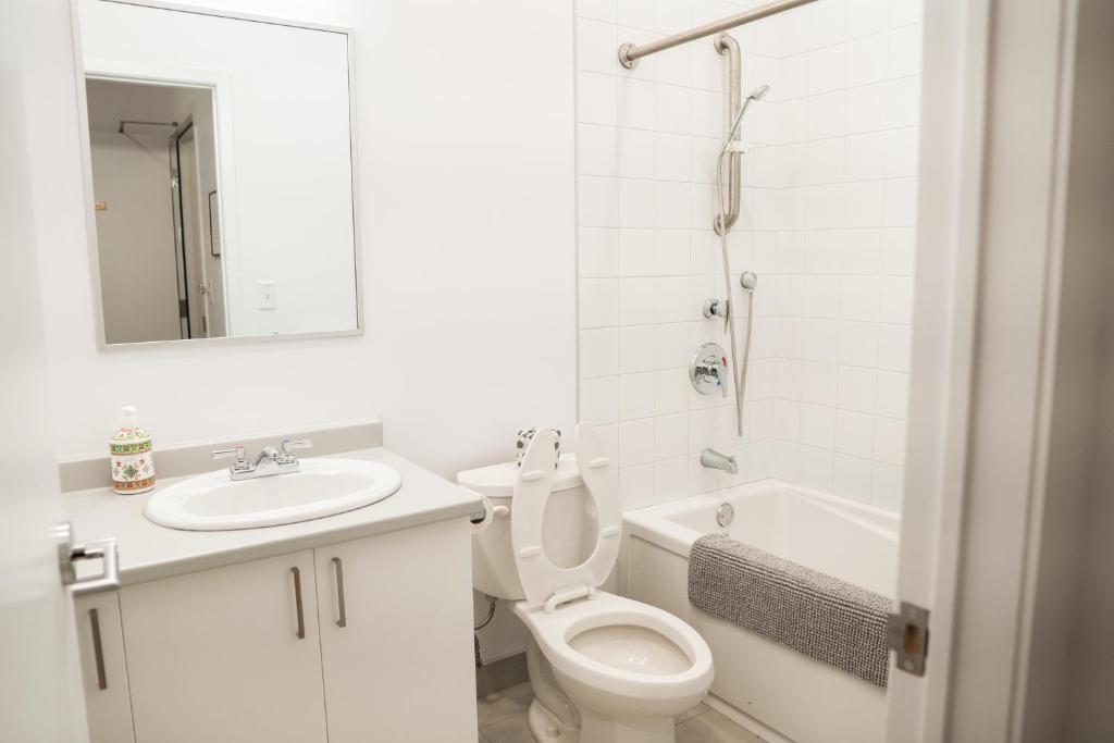 La salle de bains blanche est pourvue de toilettes et d'un lavabo. dans l'établissement Auberge de Jeunesse des Balcons, à Baie-Saint-Paul