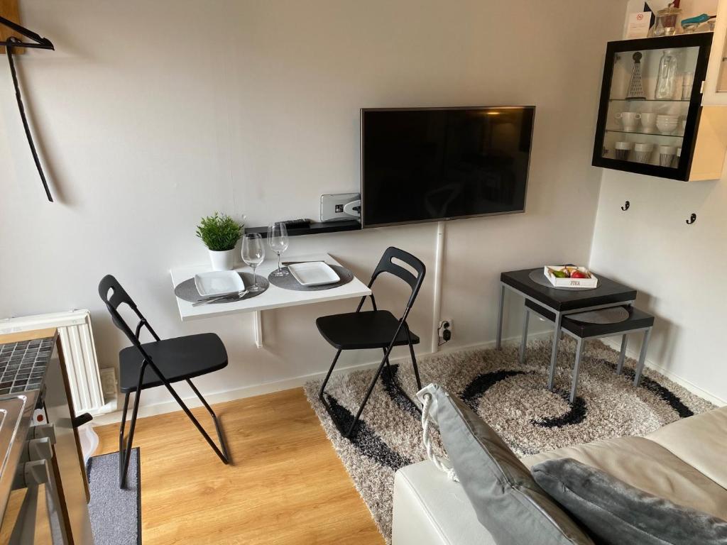 sala de estar con TV, mesa y sillas en Studio 51 Örgryte, en Gotemburgo