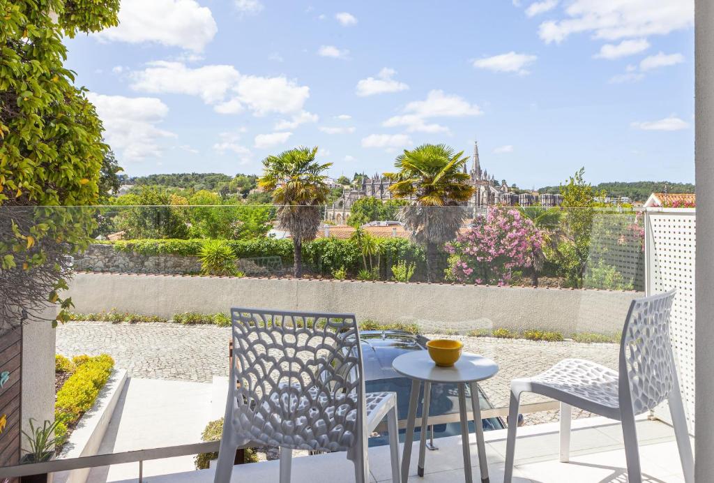 a patio with a table and chairs on a balcony at Boutique Hotel Casa do Outeiro - Arts & Crafts in Batalha