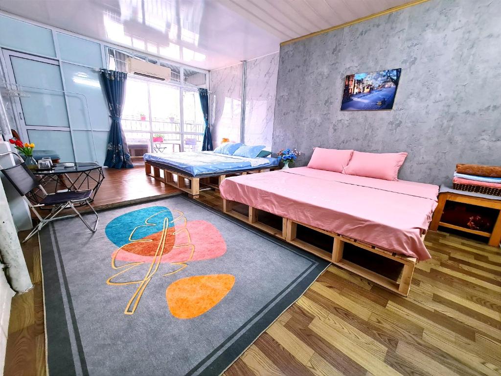 um quarto com duas camas e um tapete em H2 homestay phố cổ check in tự động em Hanói