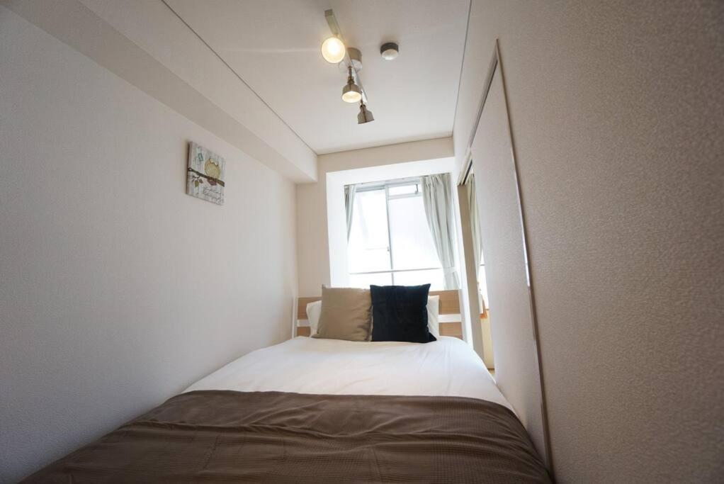 大阪市にあるApartment House Jodo 301の窓のある部屋にある小さなベッド