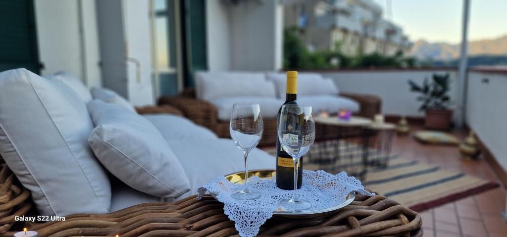 Una botella de vino y dos copas en una mesa. en Villa Silvia, en Amalfi