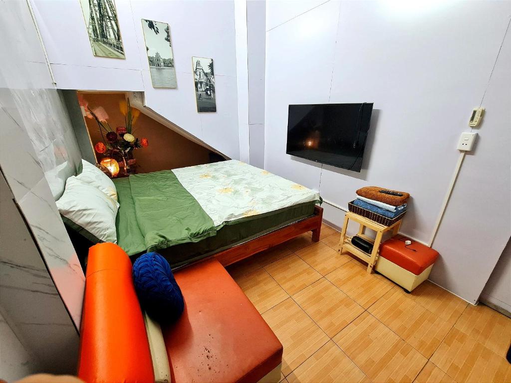a small room with a bed and a tv at H2Homestay phố cổ check in tự động in Hanoi