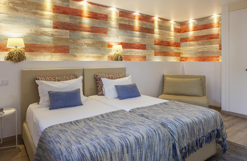 a bedroom with a large bed and a wooden wall at Boutique Hotel Casa do Outeiro - Arts & Crafts in Batalha