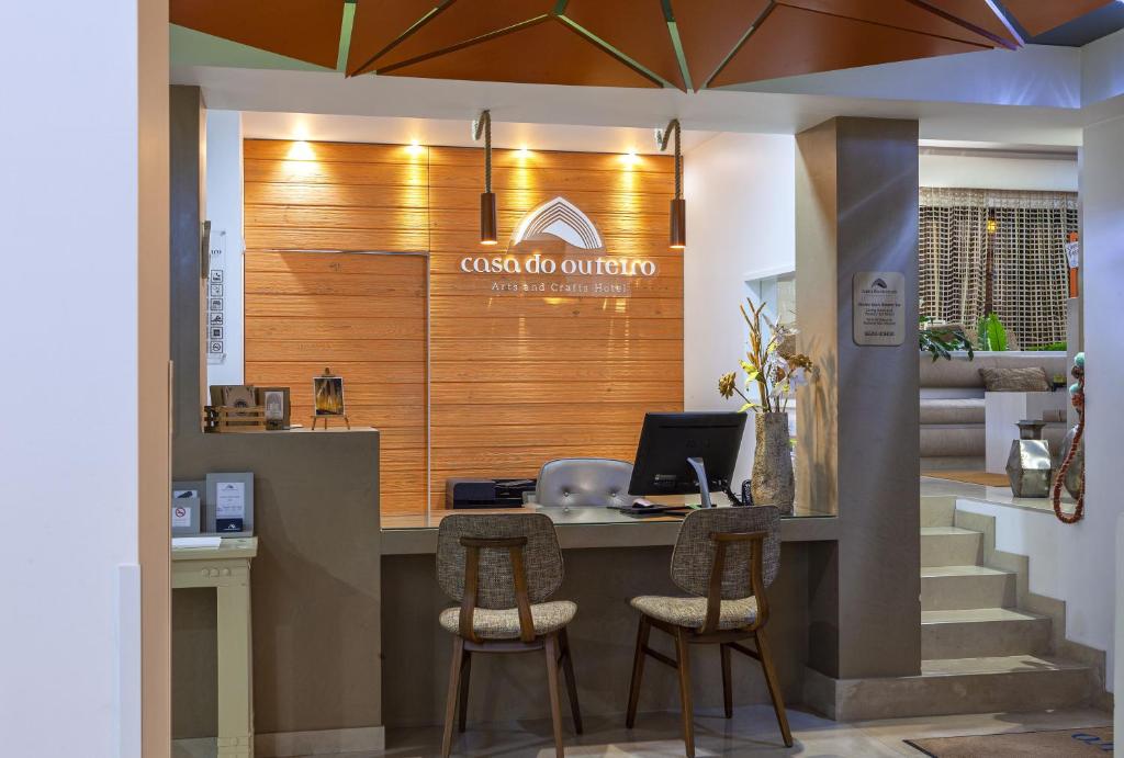 a lobby with a counter with a computer and chairs at Boutique Hotel Casa do Outeiro - Arts & Crafts in Batalha