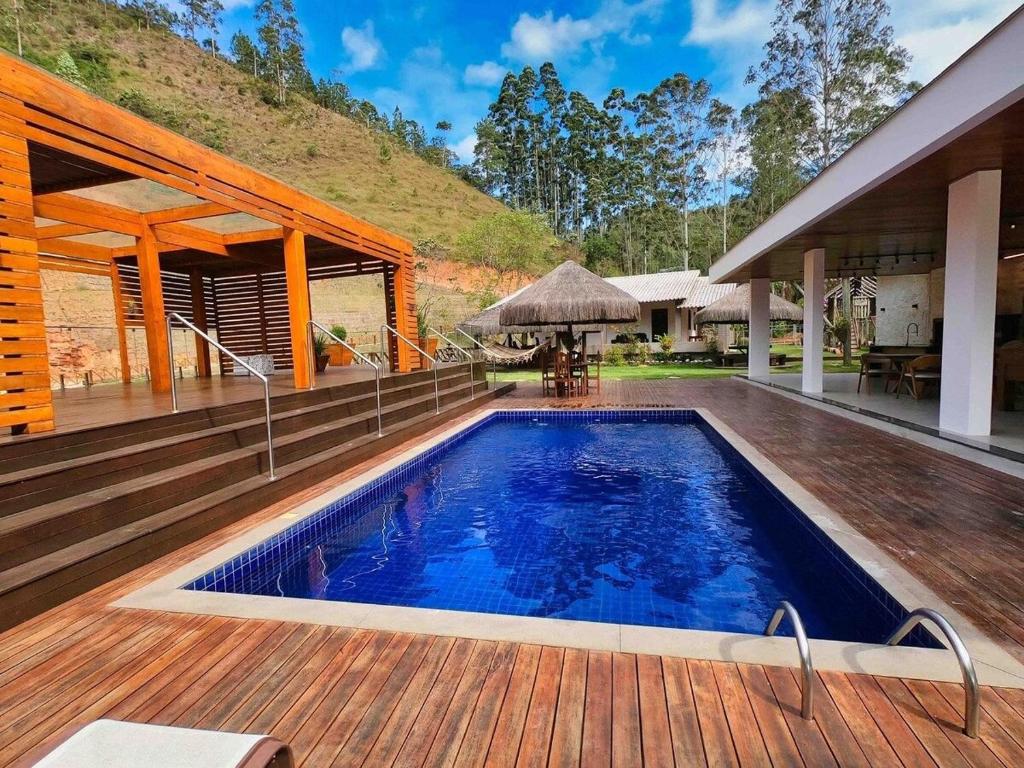 een zwembad op een terras naast een huis bij Sítio Cinco Folhas, recanto com vista pra montanha in Marechal Floriano