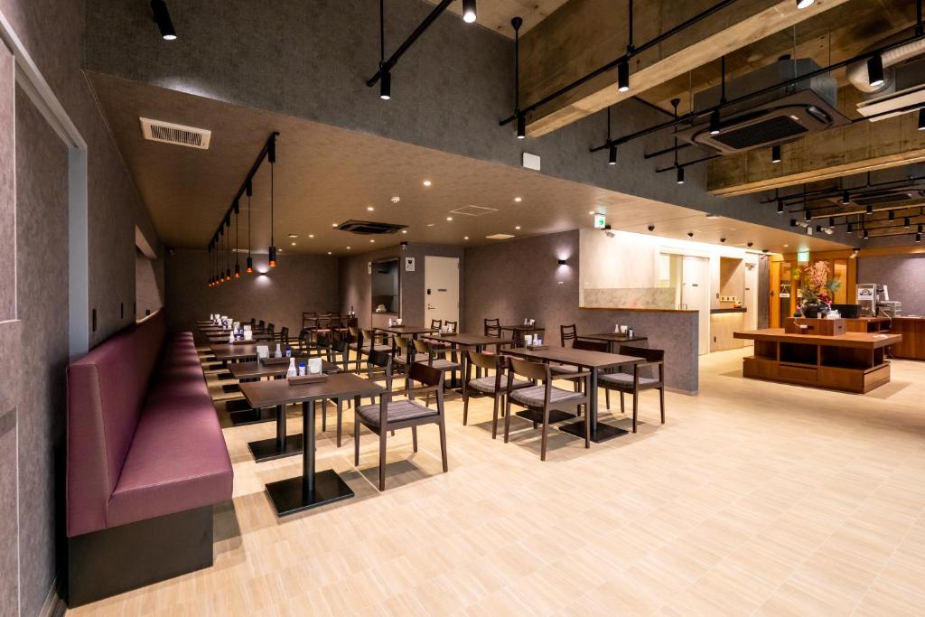 高崎Hotel Sun的一间带桌椅的餐厅和一间厨房