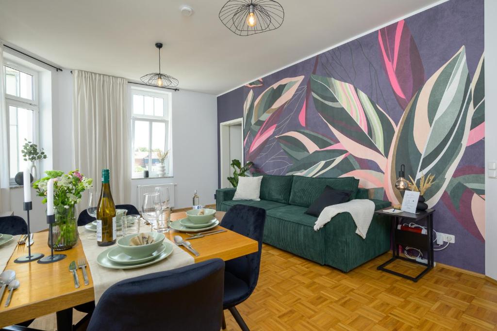 a living room with a green couch and a table at LE Vacation 3-Room-Apartment 67qm, Küche, Netflix, Free-TV in Schkeuditz